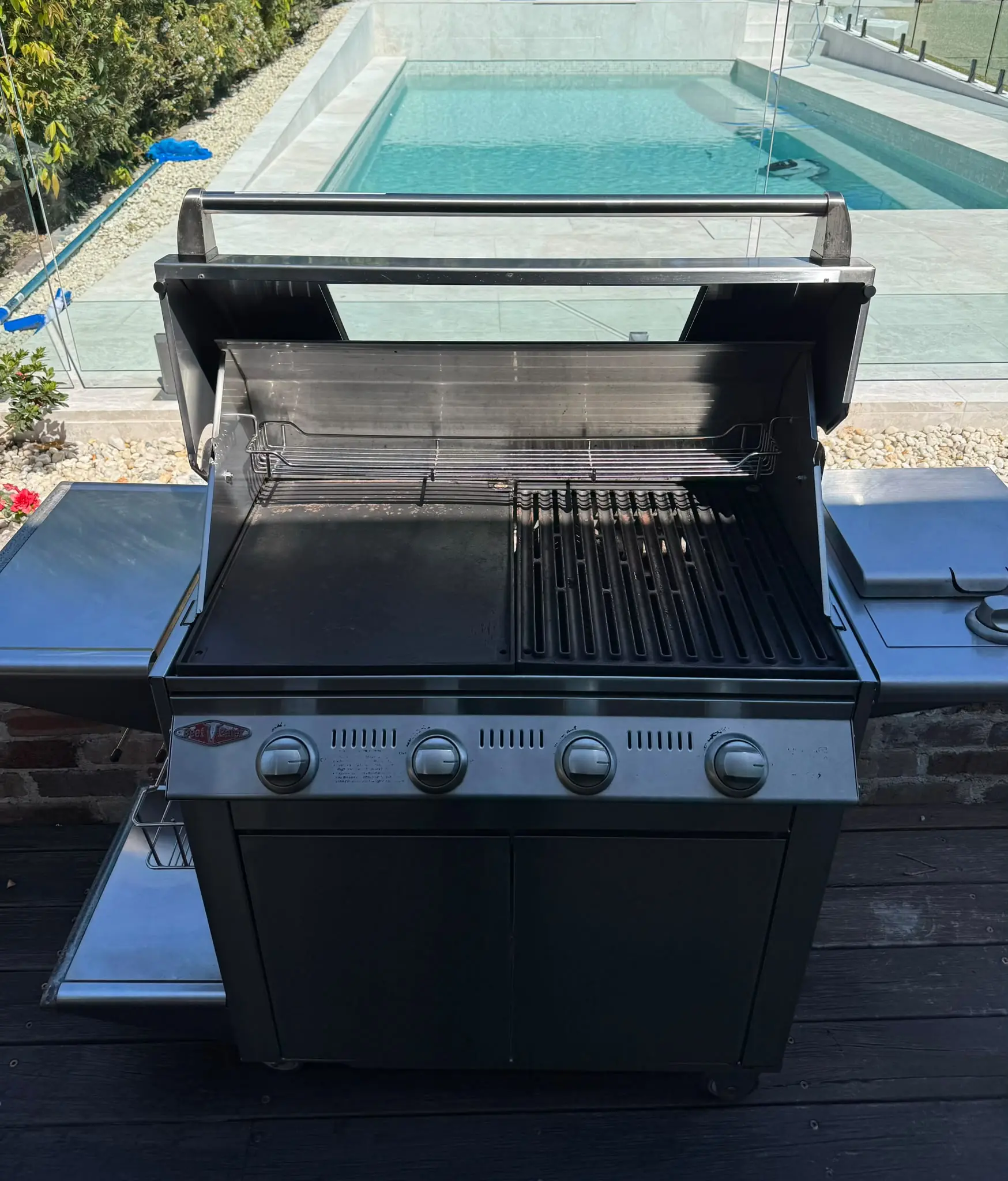 Open BeefEater four-burner BBQ showing cleaned cooking surfaces and accessible interior in Putney