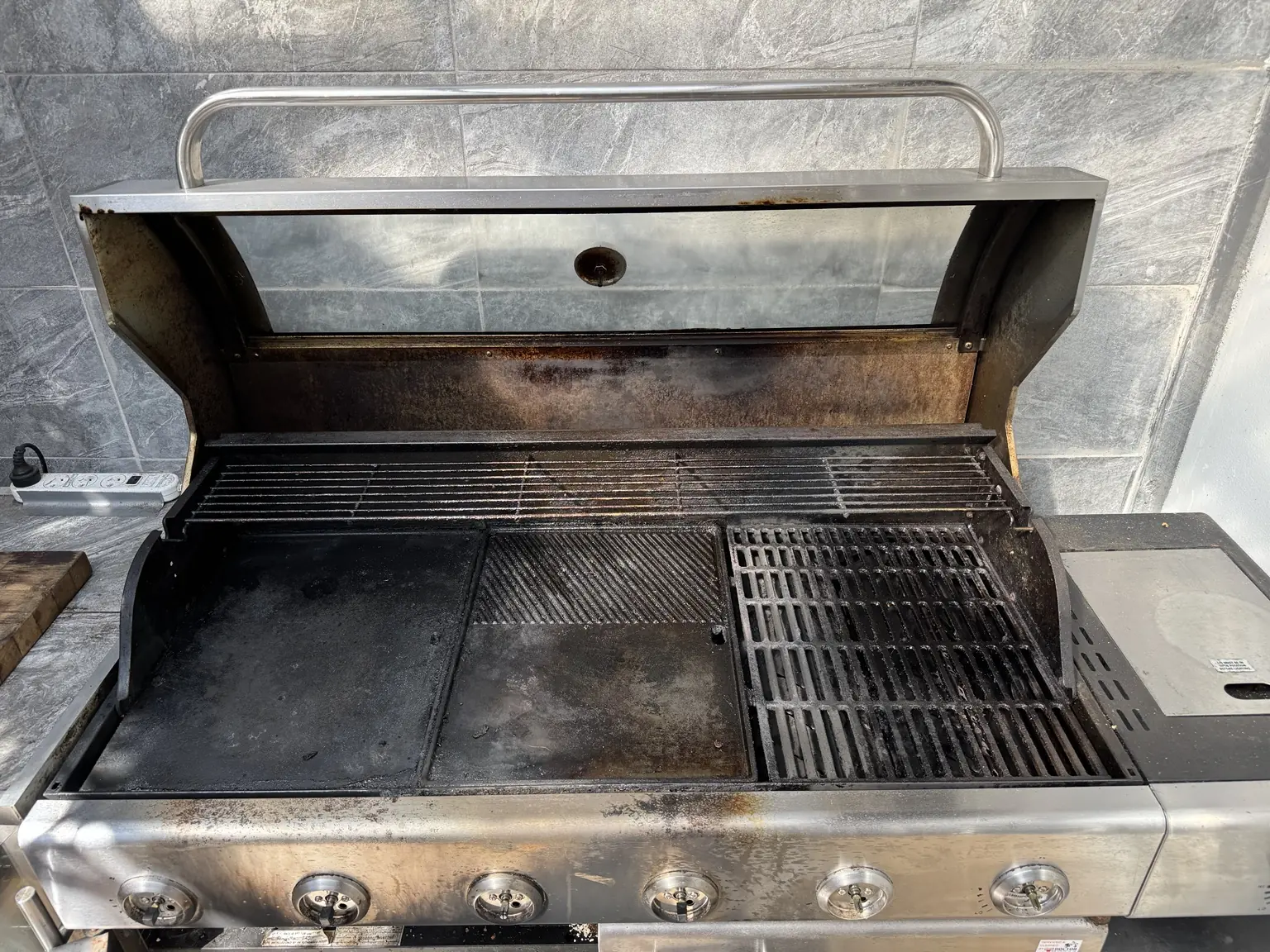 Bondi six-burner BBQ cooking area before cleaning, with grease and carbon build-up